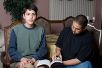 Young man reading with mentor
